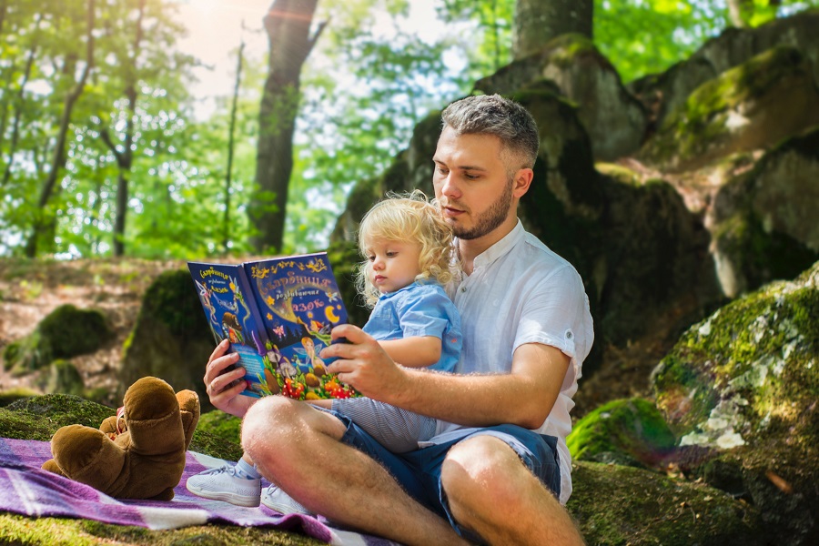 Father and daughter reading outside